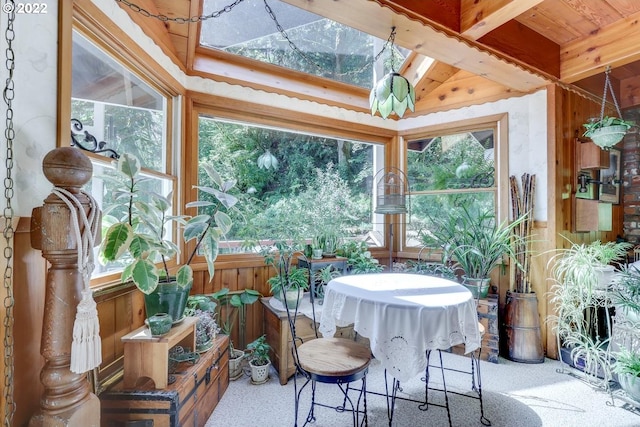 sunroom featuring plenty of natural light and lofted ceiling with beams