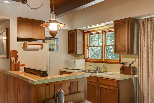 kitchen featuring beamed ceiling, decorative light fixtures, sink, and white appliances