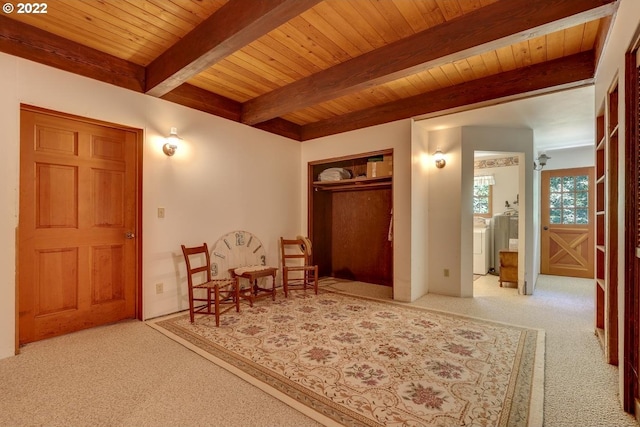 interior space featuring light carpet, beam ceiling, independent washer and dryer, and wooden ceiling