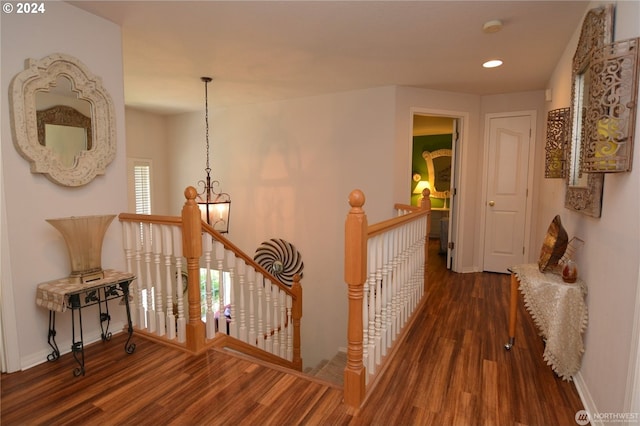 hall with an inviting chandelier and dark wood-type flooring