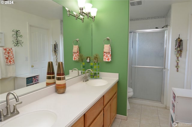 bathroom with vanity, a shower with shower door, tile patterned floors, and toilet