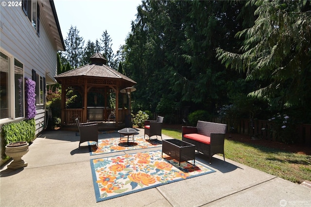 view of patio featuring a gazebo and an outdoor living space with a fire pit