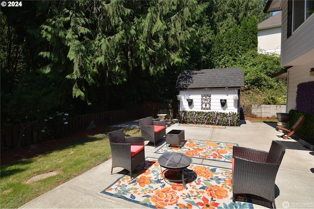 view of patio / terrace with a shed and an outdoor living space with a fire pit