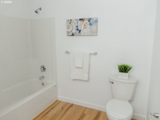 bathroom featuring wood-type flooring, toilet, and shower / bathing tub combination