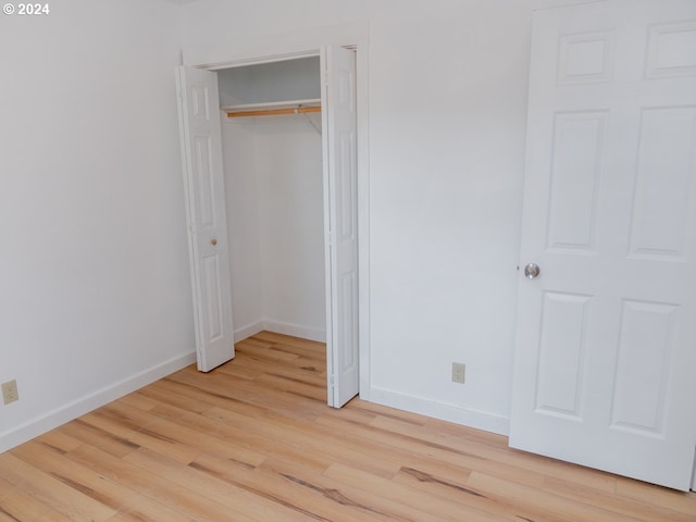 unfurnished bedroom featuring a closet and light wood-type flooring