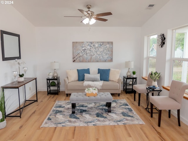 living room featuring lofted ceiling, light hardwood / wood-style flooring, and ceiling fan