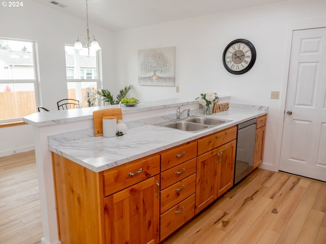 kitchen with sink, hanging light fixtures, stainless steel dishwasher, light hardwood / wood-style floors, and kitchen peninsula