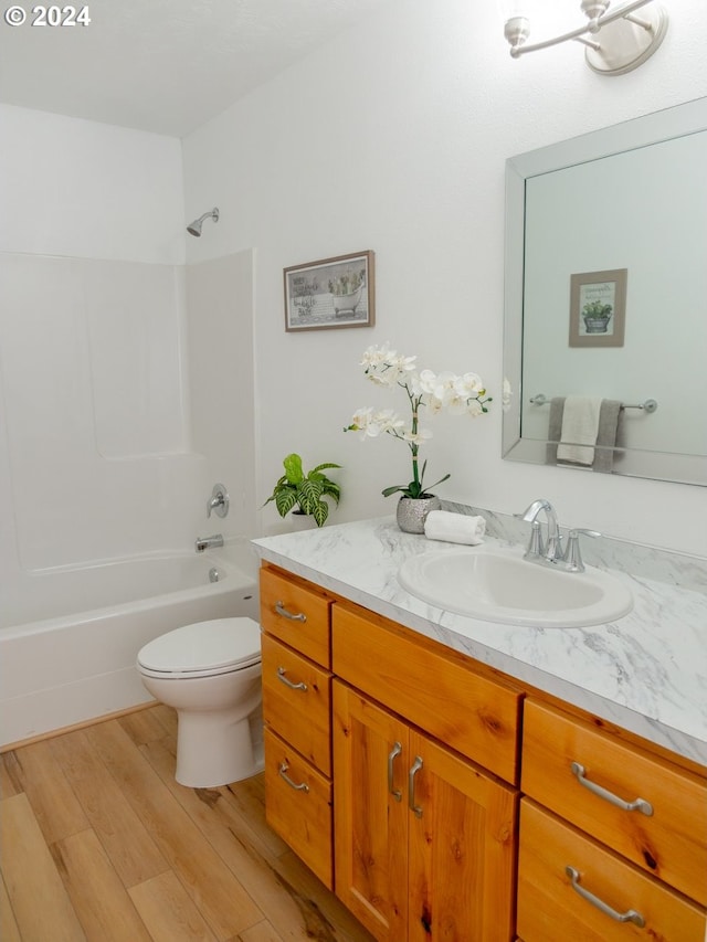 full bathroom featuring vanity, wood-type flooring, tub / shower combination, and toilet