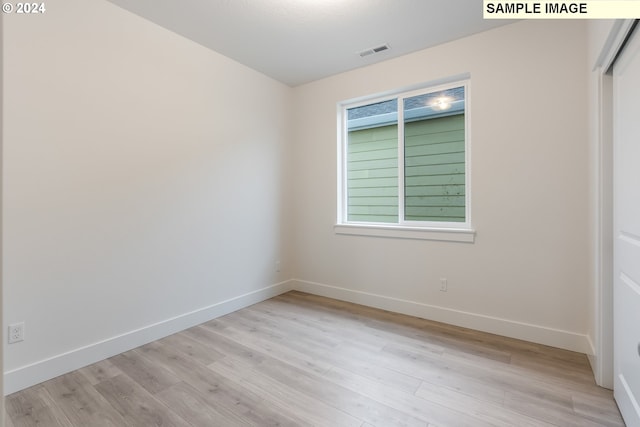 unfurnished room with light wood-type flooring