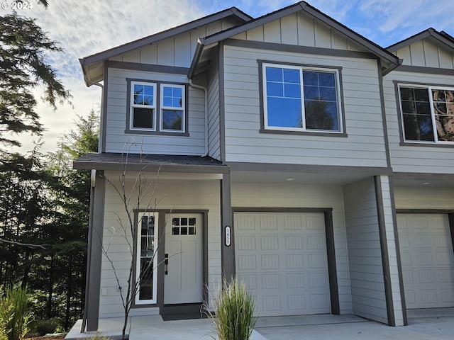 view of front facade featuring driveway, an attached garage, and board and batten siding