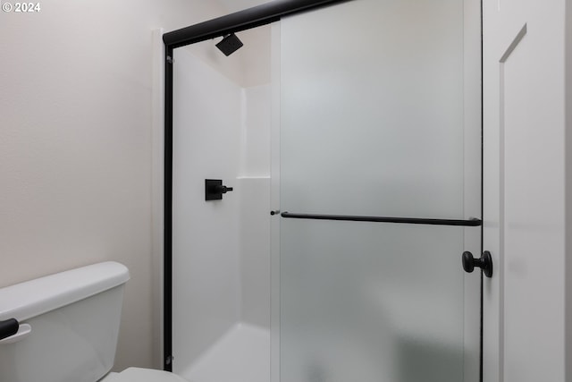 bathroom with a stall shower and toilet