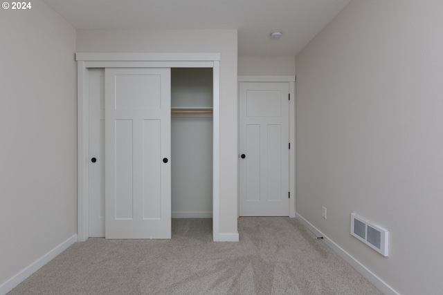 unfurnished bedroom featuring a closet, carpet flooring, visible vents, and baseboards