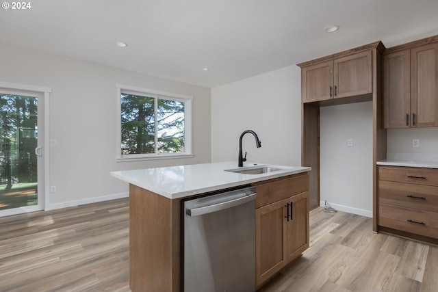 kitchen with light wood finished floors, a sink, light countertops, and dishwasher