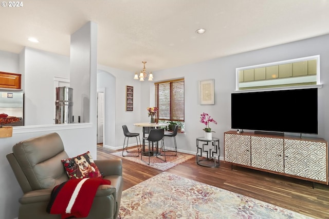 living room with a notable chandelier and dark wood-type flooring