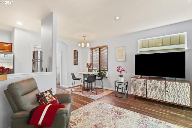 living area with a chandelier, recessed lighting, baseboards, and wood finished floors