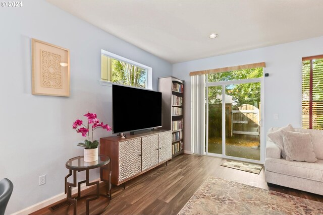 living room with recessed lighting, visible vents, baseboards, and wood finished floors