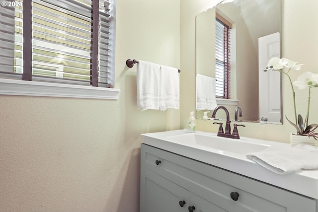 bathroom with a textured wall and vanity