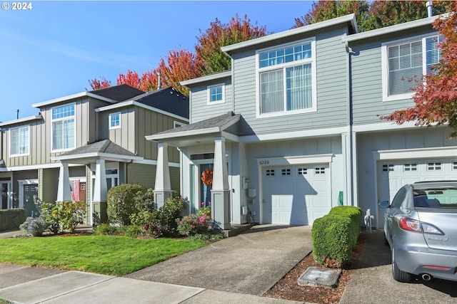 multi unit property with board and batten siding, driveway, and a garage