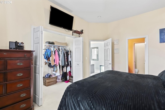 carpeted bedroom with a closet and ensuite bathroom