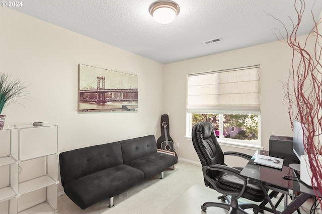 home office featuring visible vents, baseboards, carpet, and a textured ceiling