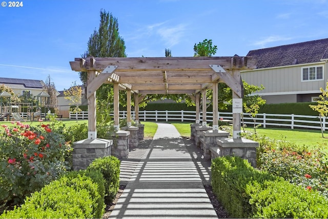view of community with a patio, a yard, a pergola, and fence