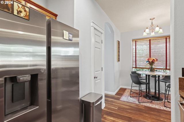 kitchen with pendant lighting, dark wood-type flooring, a chandelier, stainless steel fridge, and baseboards