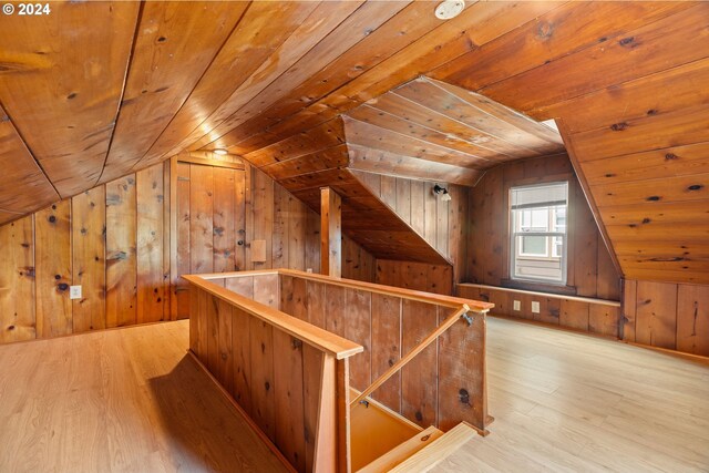 bonus room featuring wood walls, wood ceiling, lofted ceiling, and light hardwood / wood-style floors