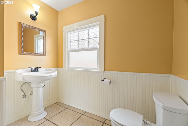 bathroom with tile patterned flooring, toilet, and radiator