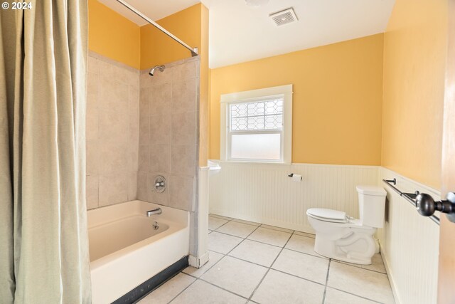 bathroom featuring tile patterned flooring, shower / bath combo, and toilet