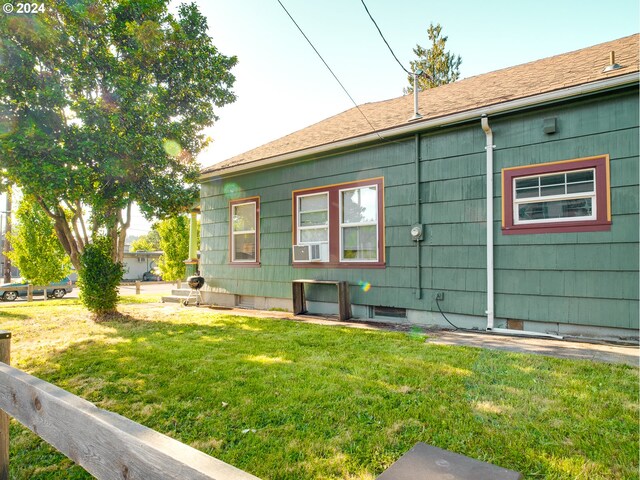 view of side of property featuring cooling unit and a lawn