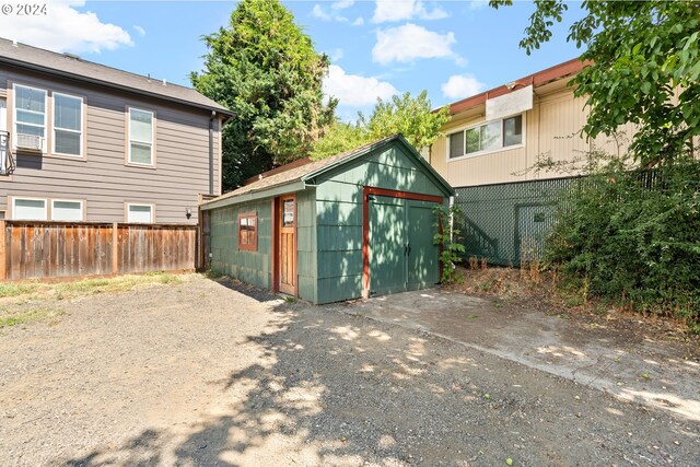 rear view of property with a storage unit