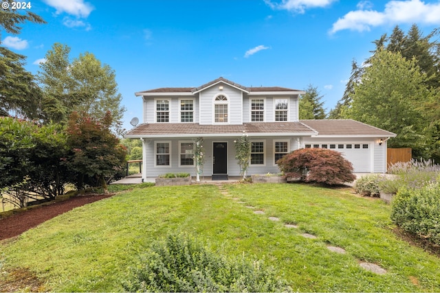 front of property with a porch, a front lawn, and a garage