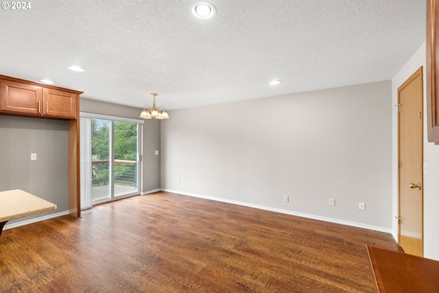 interior space with a textured ceiling, an inviting chandelier, and dark hardwood / wood-style flooring