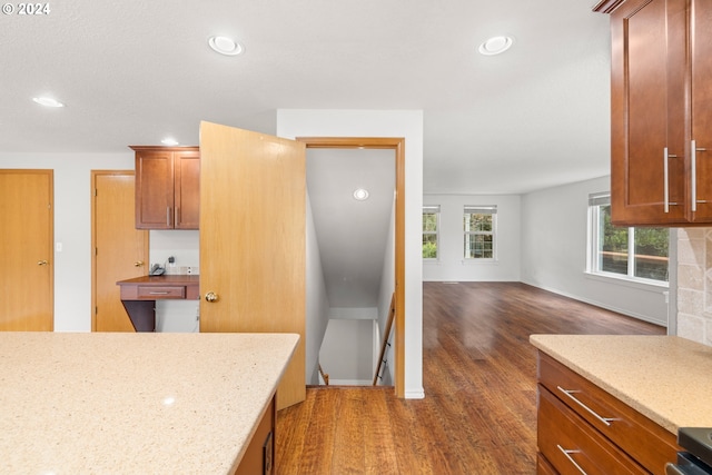 kitchen with dark hardwood / wood-style floors and light stone countertops