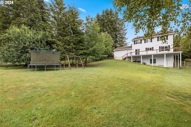 view of yard with a wooden deck and a trampoline