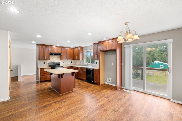 kitchen featuring dark hardwood / wood-style flooring, black dishwasher, decorative light fixtures, and electric stove