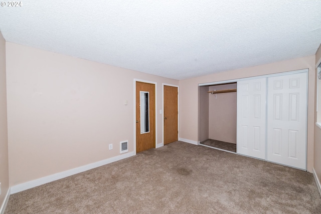 unfurnished bedroom featuring carpet flooring, a textured ceiling, and a closet