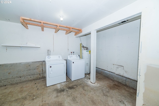 clothes washing area featuring washer and clothes dryer and water heater