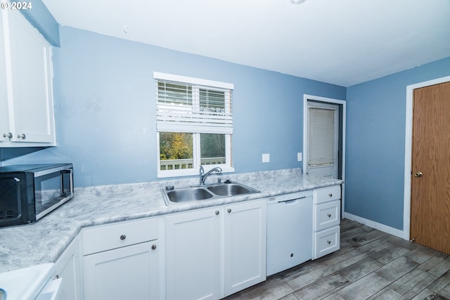 kitchen featuring dishwasher, light hardwood / wood-style floors, white cabinetry, and sink