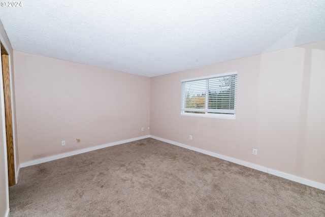 carpeted empty room with a textured ceiling