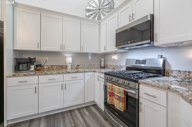 kitchen featuring light stone countertops, stainless steel appliances, dark wood-type flooring, and white cabinetry