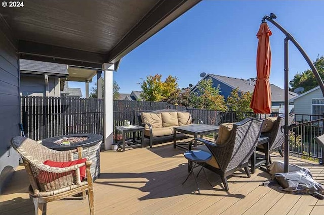 deck featuring an outdoor living space with a fire pit