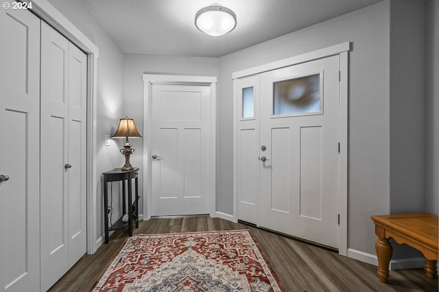 foyer with baseboards and dark wood-style floors