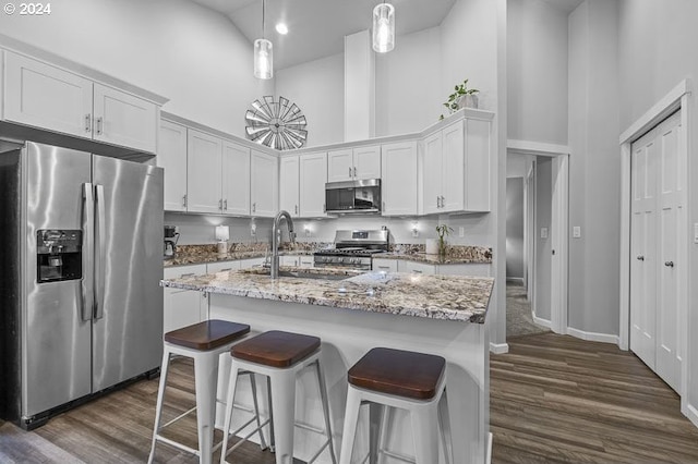kitchen with white cabinets, stainless steel appliances, high vaulted ceiling, and dark wood-type flooring