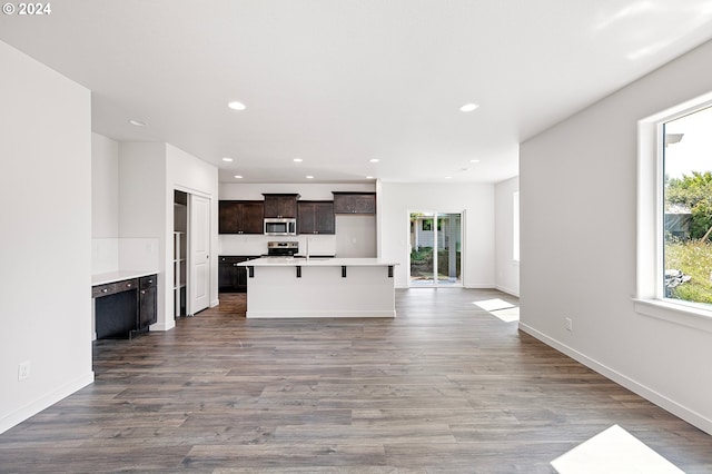 kitchen with a kitchen breakfast bar, wood-type flooring, and an island with sink