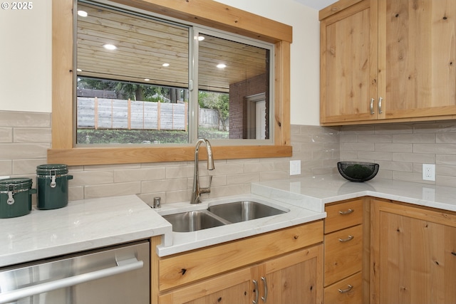 kitchen featuring tasteful backsplash, stainless steel dishwasher, and sink