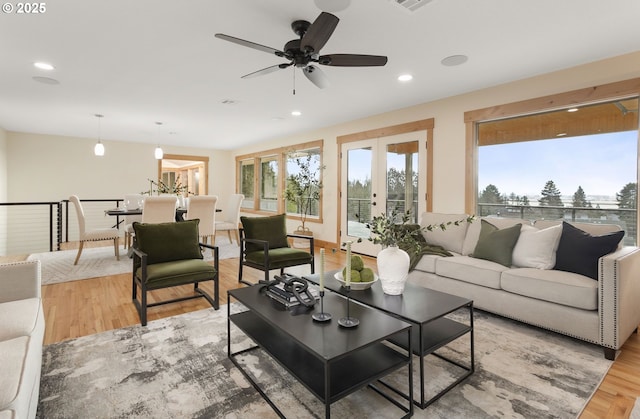 living room with light hardwood / wood-style flooring, plenty of natural light, and ceiling fan