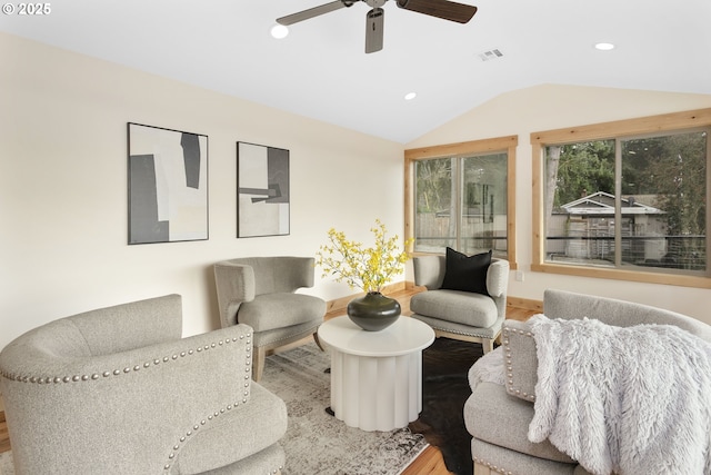 living room with ceiling fan, wood-type flooring, and lofted ceiling