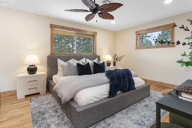 bedroom with multiple windows, ceiling fan, and light wood-type flooring