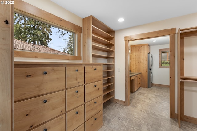 walk in closet with stacked washer and dryer